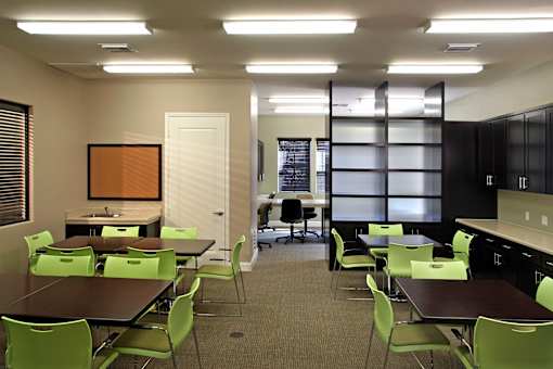 A conference room with green chairs and a brown table.