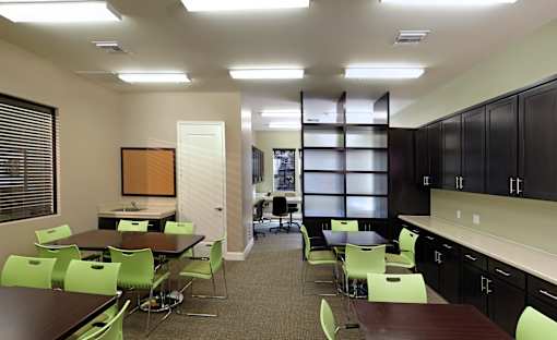 A conference room with green chairs and a long table.