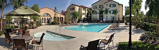 A large swimming pool surrounded by chairs and umbrellas.