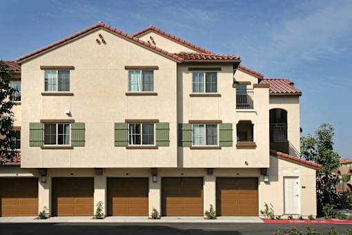 A two-story house with a red tile roof and a garage.