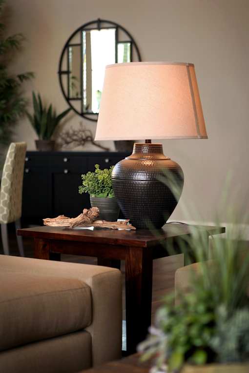 A table with a lamp and a vase on it.