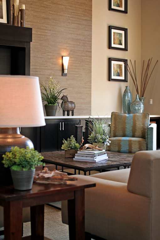 A living room with a lamp, a couch, and a table with a plant on it.