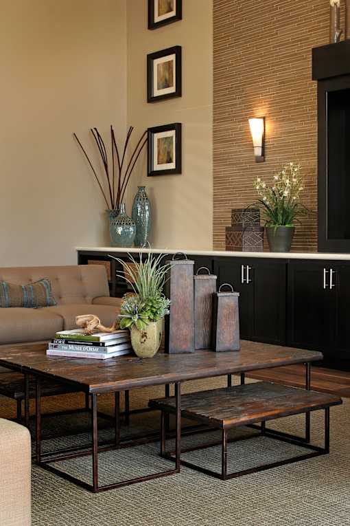 A living room with a brown sofa, a coffee table, and a fireplace.
