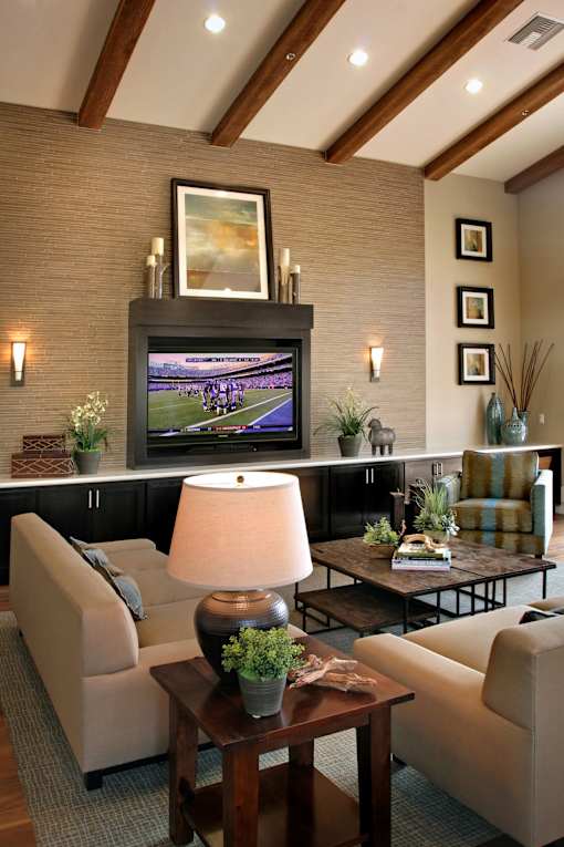 A living room with a flat screen TV mounted above a coffee table.