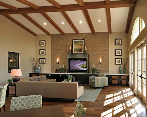 A living room with a brown couch and a television on a black stand.