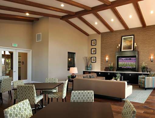 A living room with a couch, chairs, and a television.