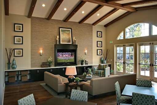 A living room with a couch, chairs, and a television.