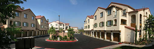 A row of houses with a red brick walkway in front.