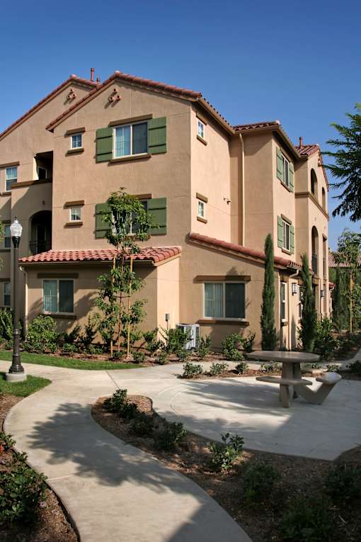 A building with a red tile roof and green shutters.