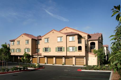 A large, multi-story building with a red roof and a driveway in front.