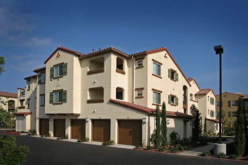 A row of houses with garages and green shutters.
