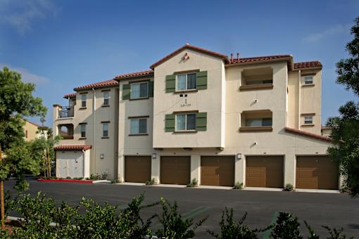 A large two story building with a red tile roof and a garage door.