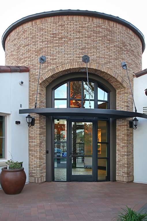 A building with a large arched doorway and a planter in front.