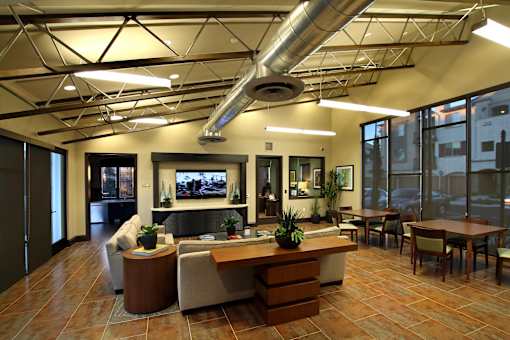 A modern office lobby with a reception desk and seating area.