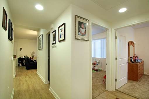 A hallway with a black couch and pictures on the wall.