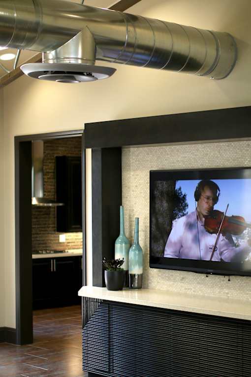 A modern living room with a television displaying a man playing a violin.