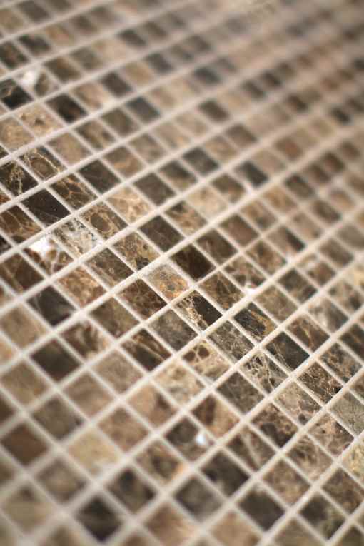 A close up of a brown and beige marble mosaic tile.