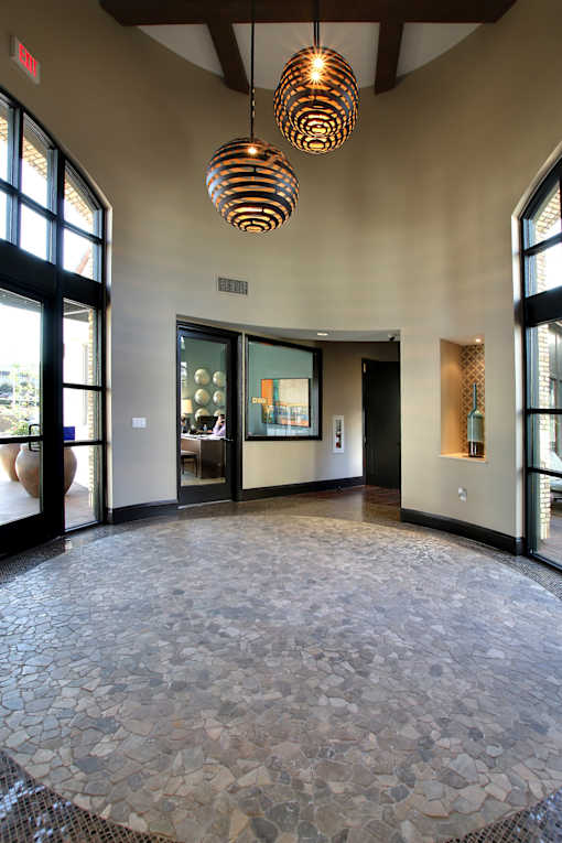 A hallway with a circular stone floor and a hanging light fixture.
