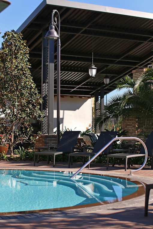 A pool with a slide and a tree in the background.