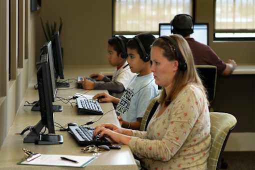 A group of people are working on computers in a room.