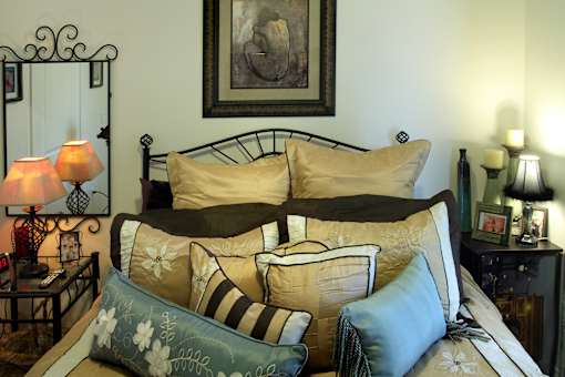 A bed with a striped pillow and a floral pillow is in the foreground.