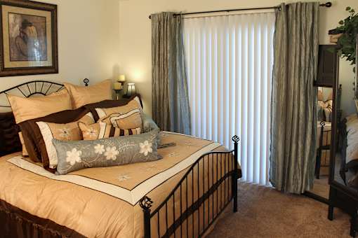 A bedroom with a large bed and a painting on the wall.