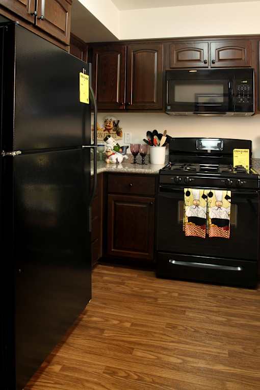 A black refrigerator with a yellow sticker on it.