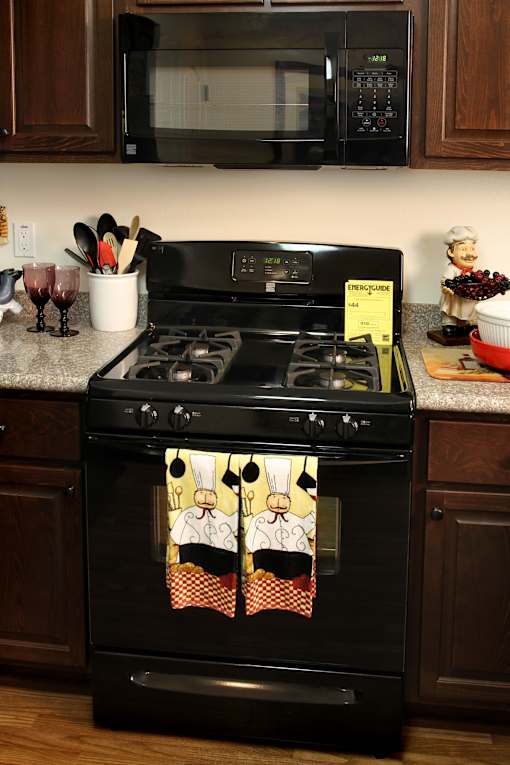 A black stove with a pot on it in a kitchen.
