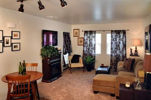 A living room with a brown couch, a wooden table, and a fireplace.