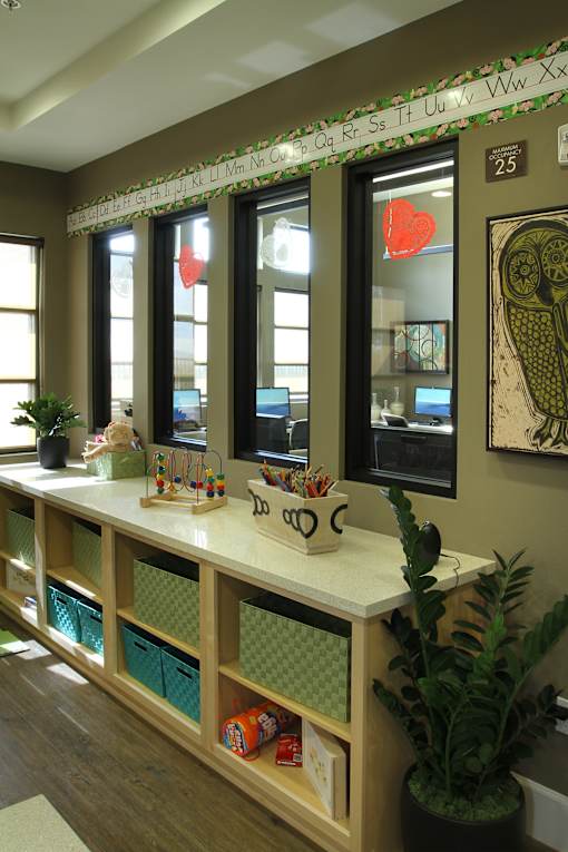 A reception desk with a white counter and a green plant on it.