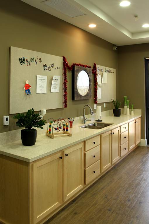 A kitchen with a white counter top and wooden cabinets.