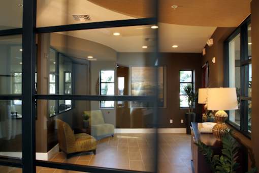 A modern living room with a glass door and a yellow armchair.