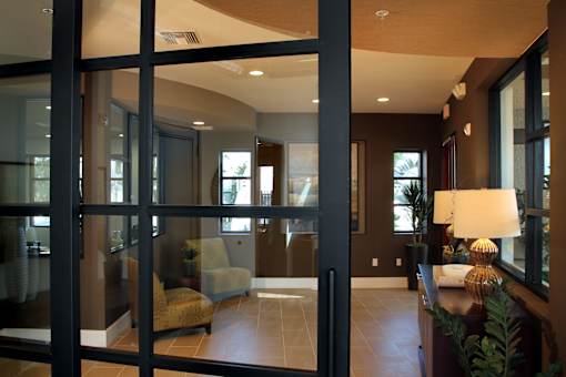 A modern living room with a glass door and a brown sofa.