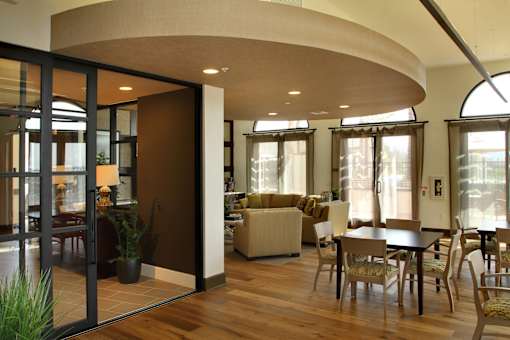 A modern living room with a curved ceiling and a glass door.