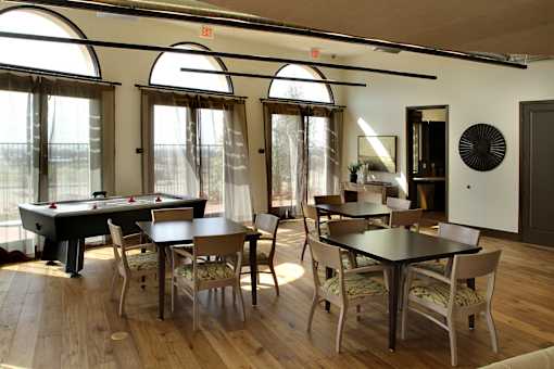 A room with a pool table and a dining table.