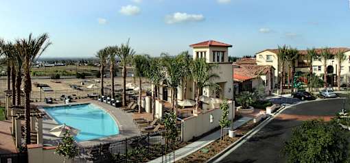 A view of a resort with a pool and palm trees.