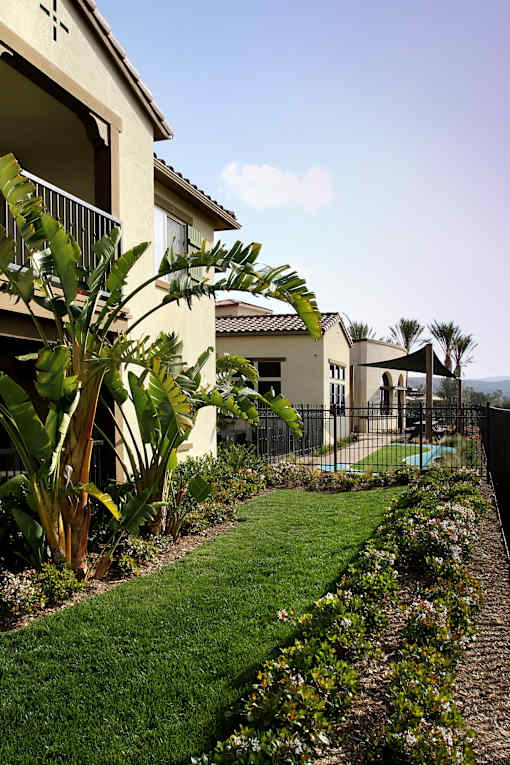 A house with a well-manicured lawn and a pool in the backyard.