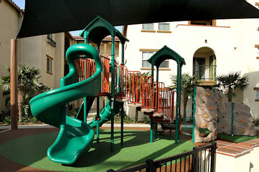 A green slide in a playground.