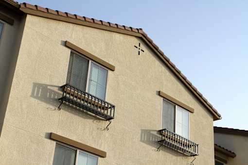 A building with two balconies and a cross symbol on the roof.