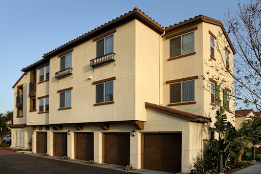 A two-story building with a beige facade and brown garage doors.