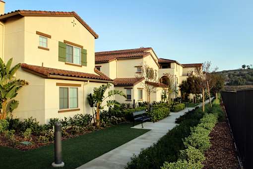 A row of houses with green plants in front.