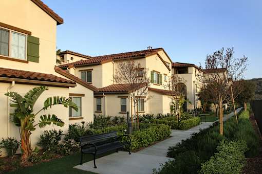 A row of houses with a bench in front of them.