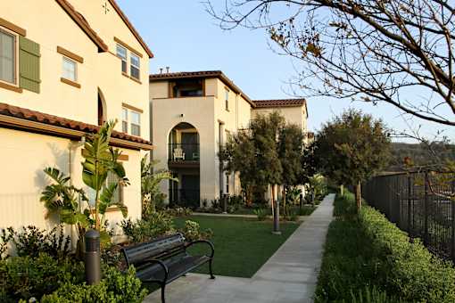 A bench is on a sidewalk in front of a building.