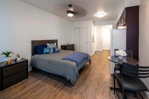 A bedroom with a bed, chair, and table.