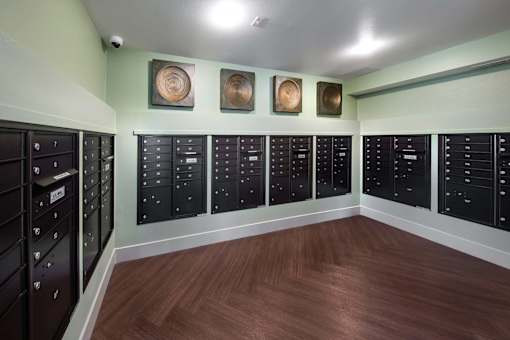 A room with black lockers and wood floors.