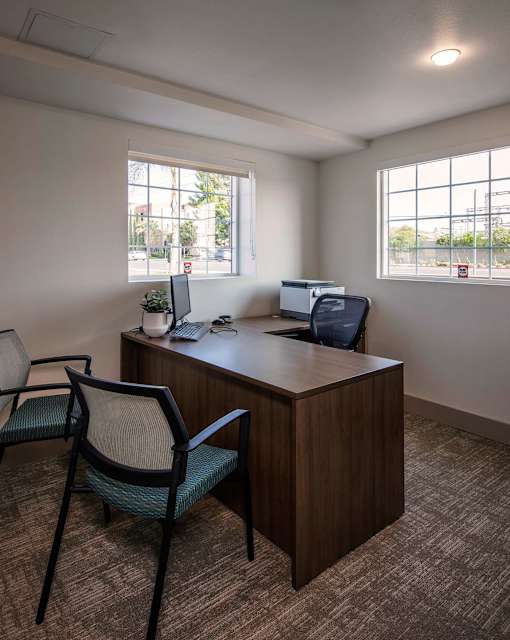 A room with a desk and chairs.