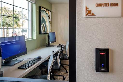 A computer room with two monitors and a keyboard.