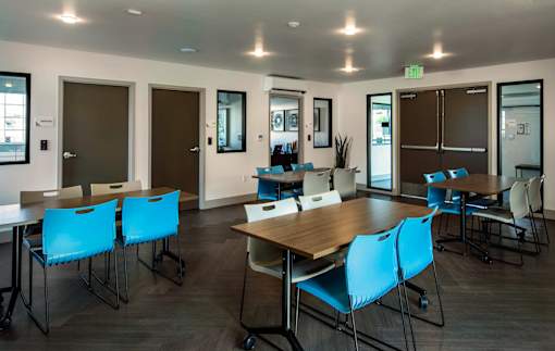 A conference room with blue chairs and a wooden table.