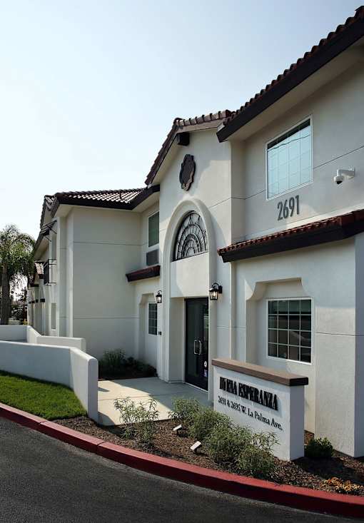 A white house with a brown roof and a black door.