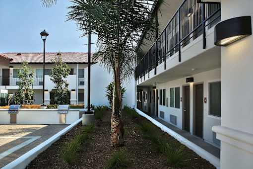 A building with a red tile roof and a balcony with black railings.